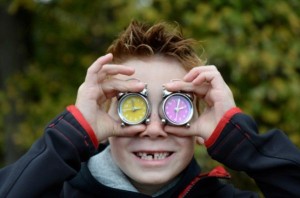 Elementary school pupil Vincent holds two alarm clocks in front of his face in Friedrichshafen, Germany, 23 October 2014. Clocks are going to be turned back by one hour to wintertime on 26 October 2014. Photo: Felix Kaestle/dpa