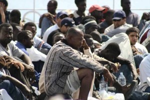 Asylum seekers, part of the some 350 Africans who arrived 14 and 15 June 2003 on the island of Lampedusa wait to betransferred by police to Agrigento, Lampedusa main city,16 June 2003. The xenophobic leader of Italy's Northern League and cabinet minister Umberto bossi suggested today using cannons to combat the growing problem of immigration, as the government prepares to implement more restrictive asylum policies. AFP PHOTO/ANSA/FRANCO LANNINO
